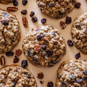 Oatmeal cookies with cranberries and pecans on a light surface.