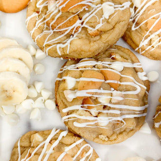 Cookies with white chocolate drizzle on a white surface