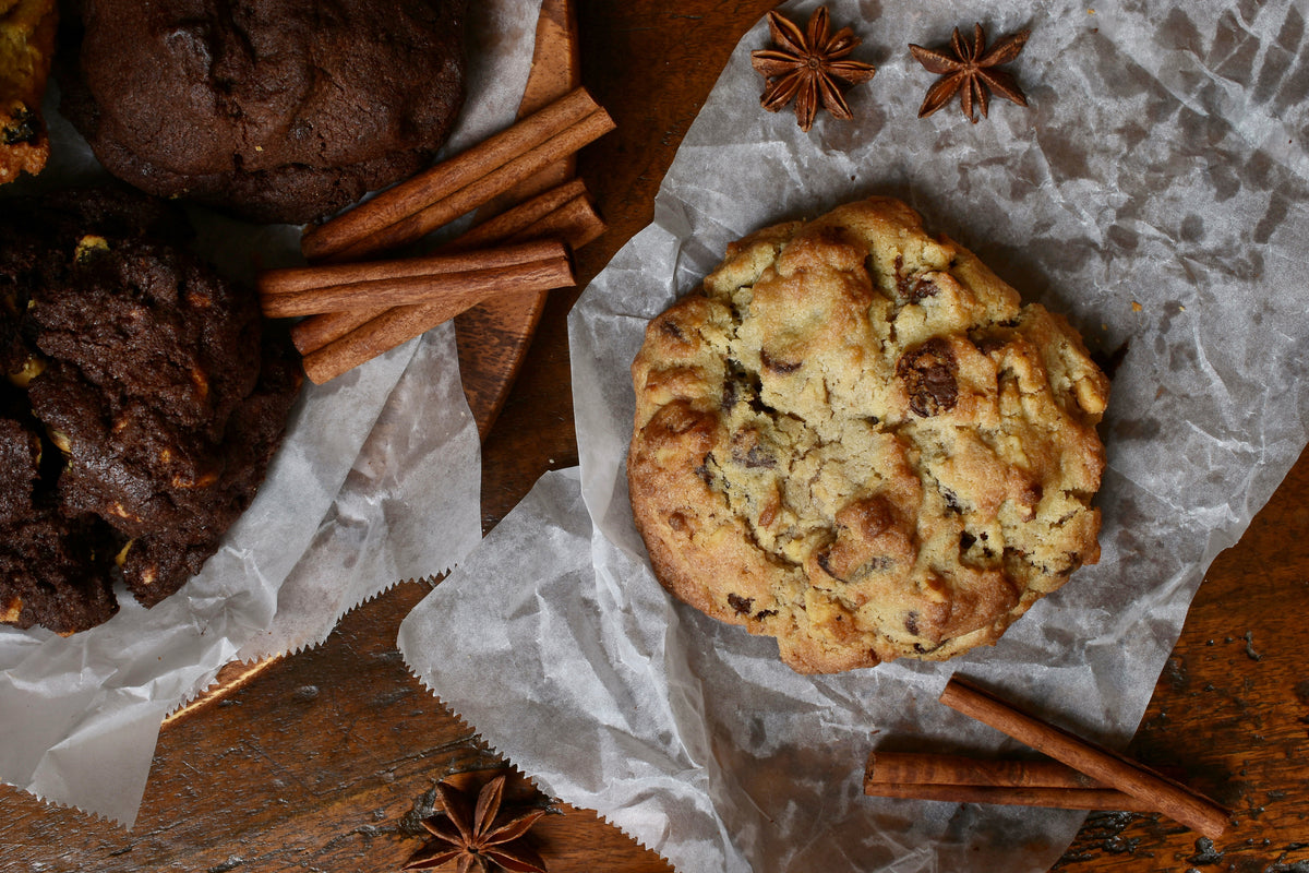 Cookies on a wooden surface with cinnamon sticks and star anise.