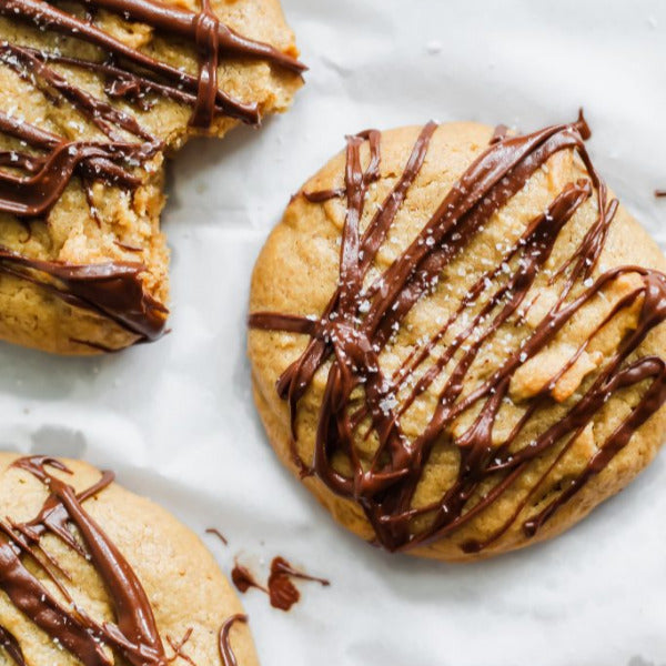 Cookies with chocolate drizzle on a marble surface
